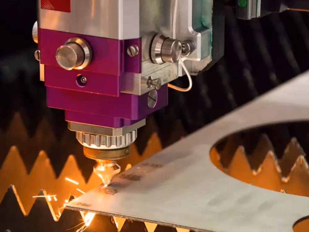 Close-up of a laser cutting machine cutting a metal sheet with sparks