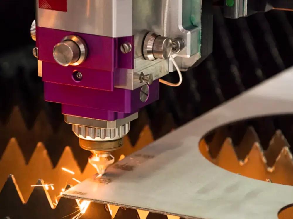 Close-up of a laser cutting machine cutting a metal sheet with sparks